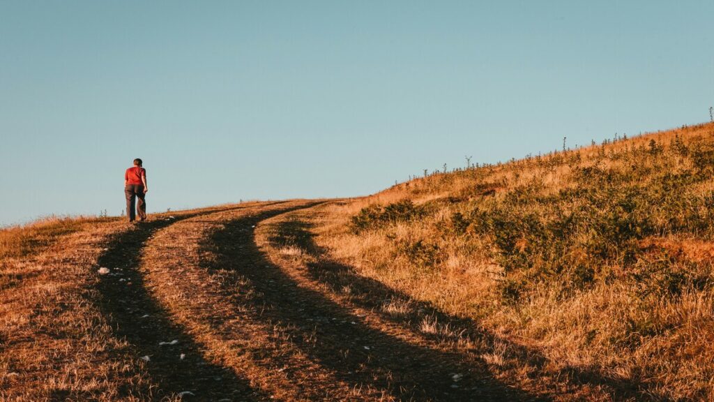 mujer en el campo en un camino para caminar con pendiente
